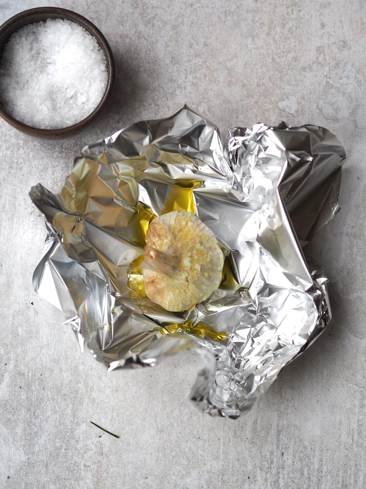 Preparing garlic to bake in oven.