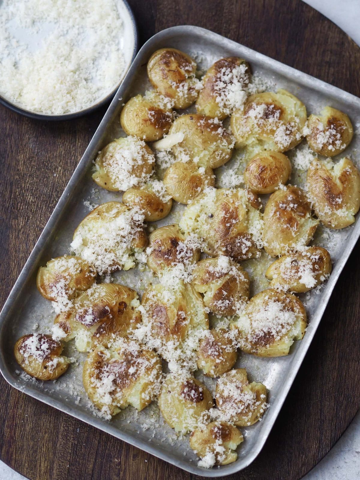 Sprinkling the potatoes with Parmesan.
