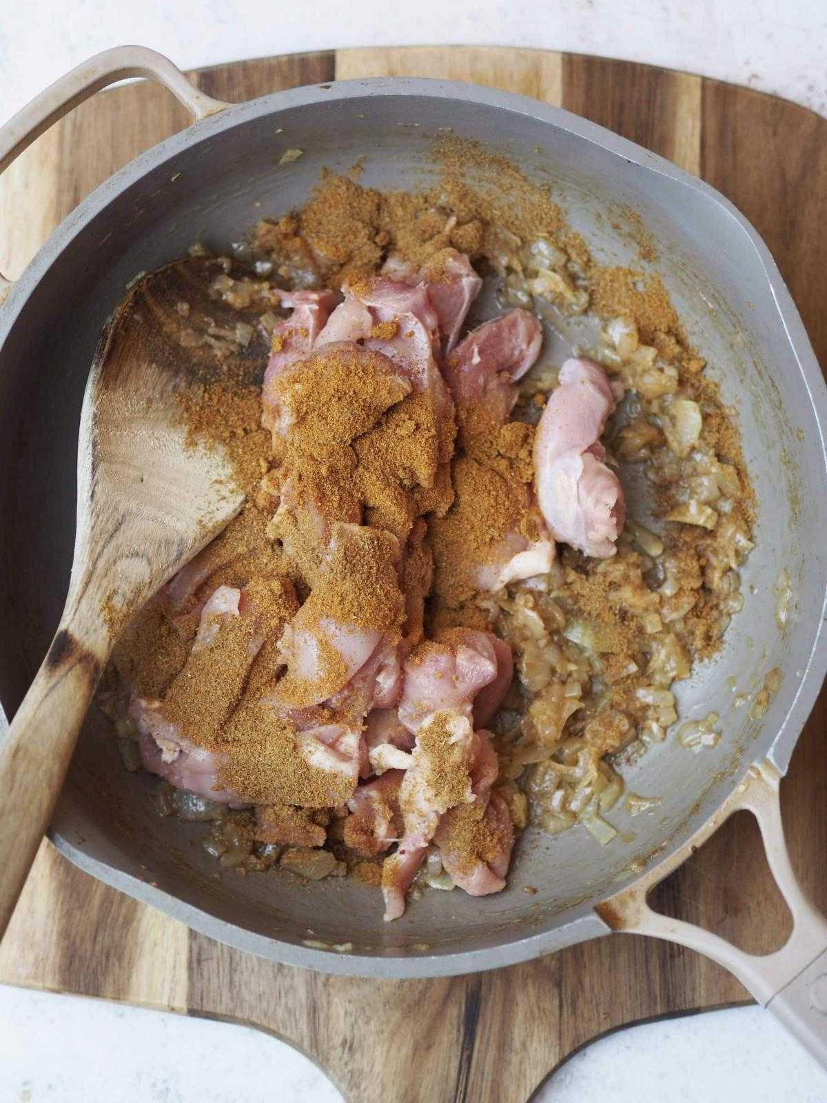 frying chicken with spices and onions.