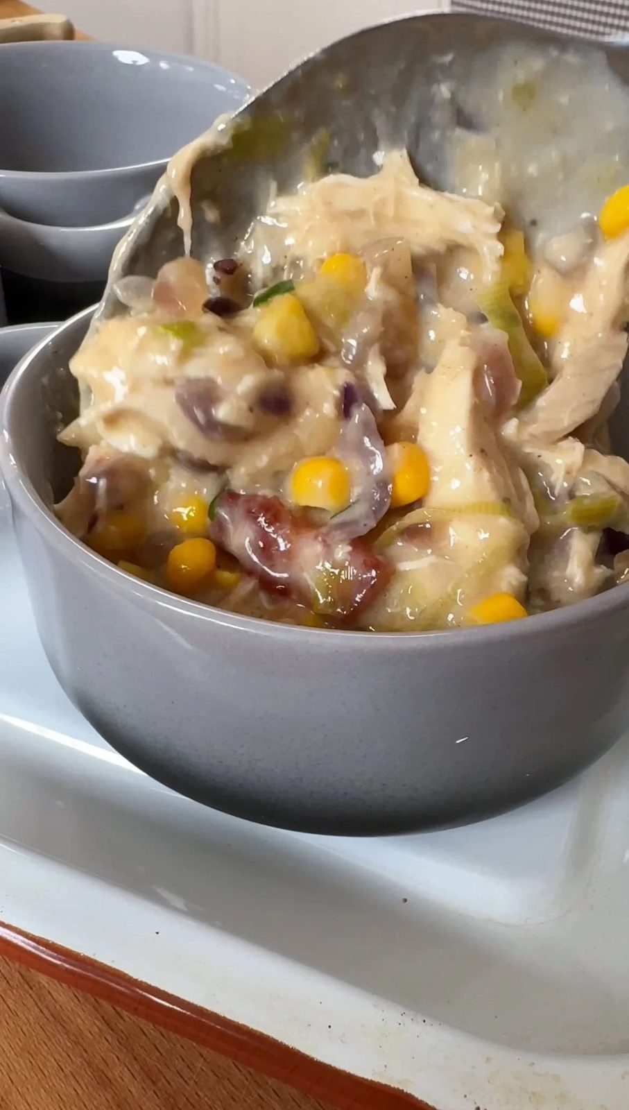 Pouring chicken pot pie filling into ramekins.