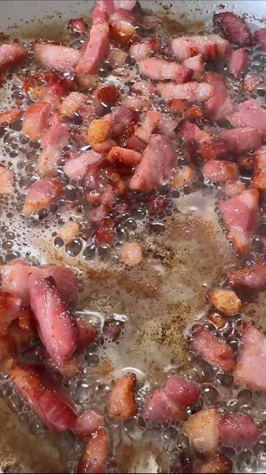 Pancetta frying in pan.