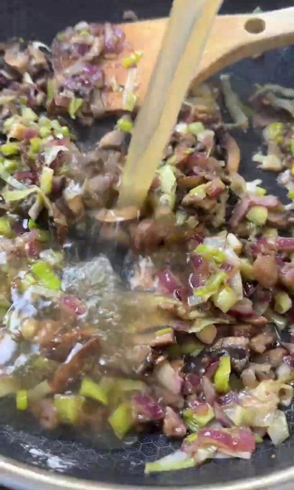 Adding stock to roux in pan.