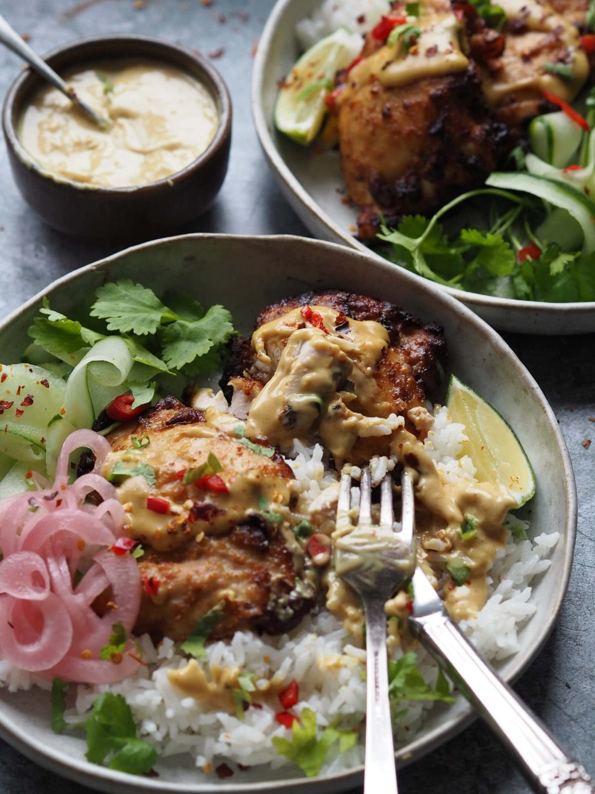 Chicken satay rice bowl with forks.