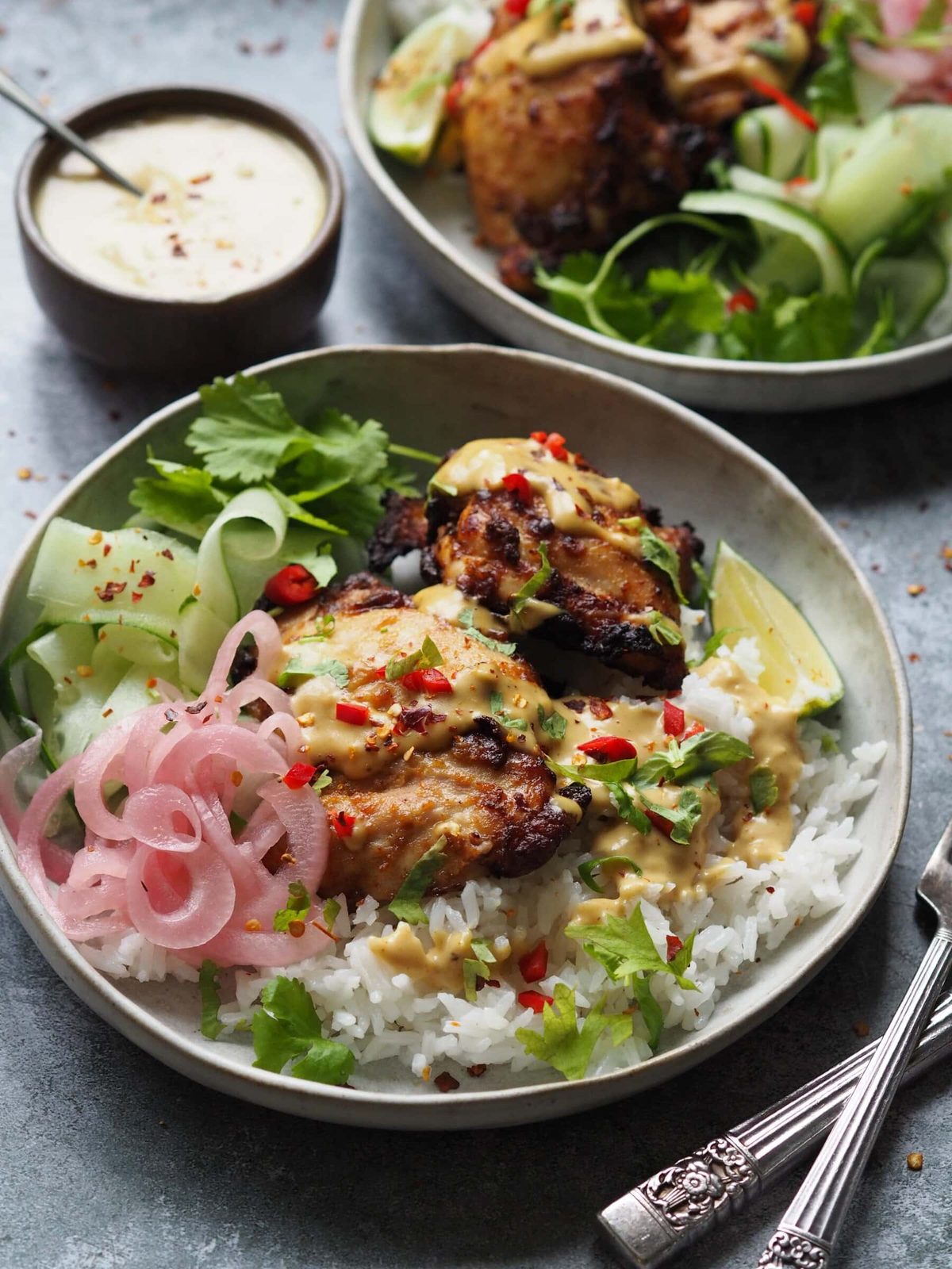 Chicken satay rice in grey serving bowl with sides.
