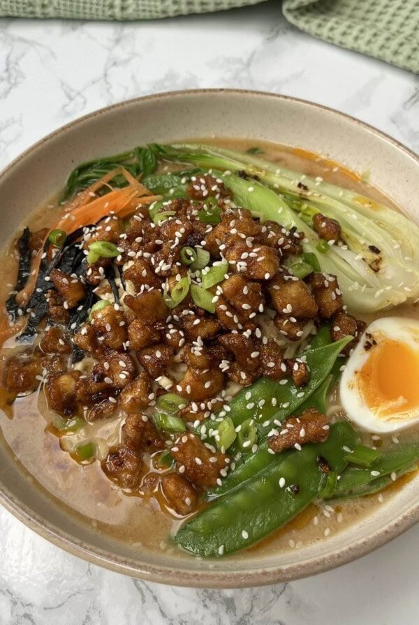 Bowl of easy pork ramen topped with an egg and pak choy