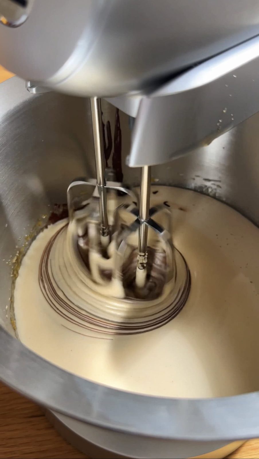 whisking the chocolate brownie batter with an electric mixer