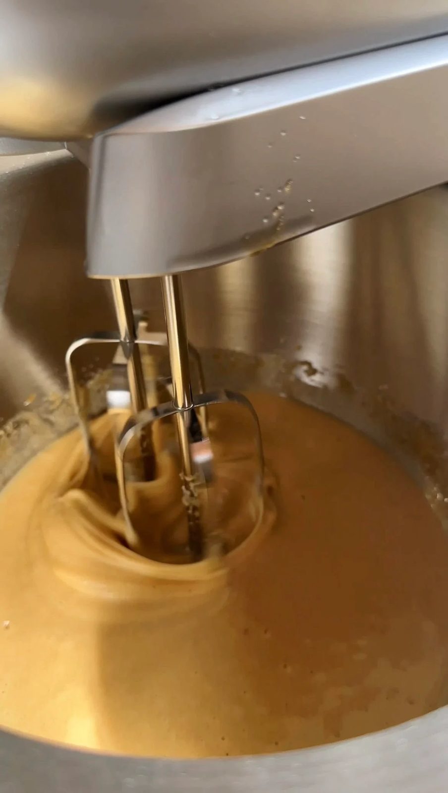 whisking the chocolate brownie batter with an electric mixer