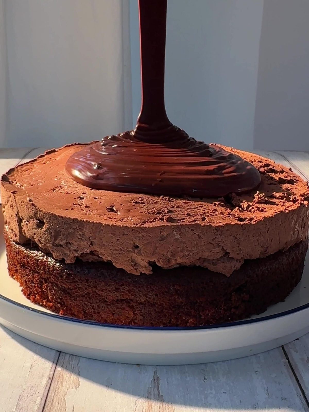 Pouring the ganache over the chocolate cake.