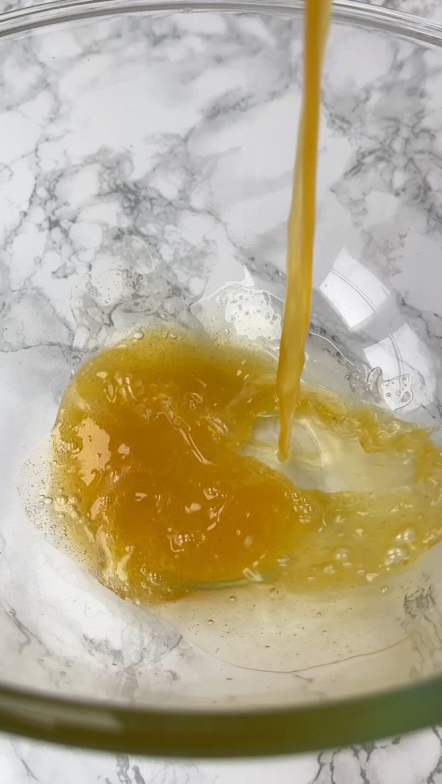 Pouring browned butter into glass bowl.