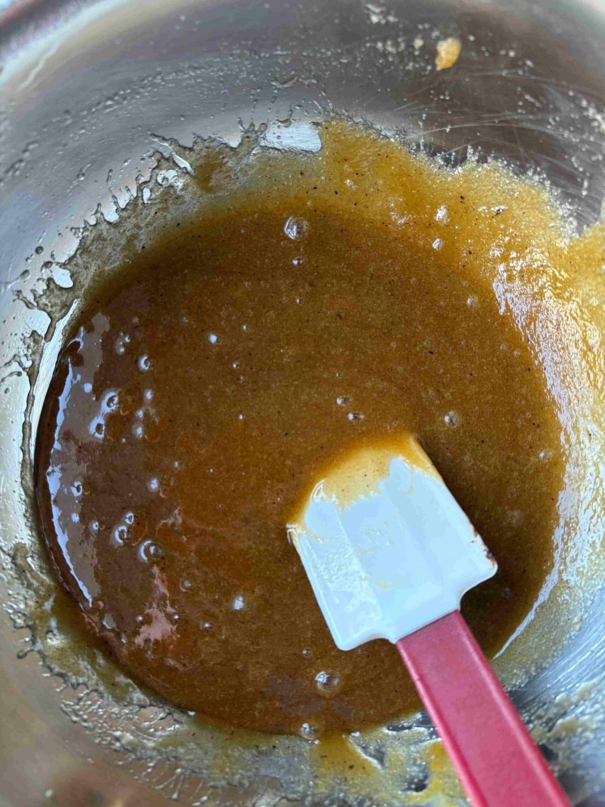 Stirring eggs and vanilla into cookie dough.