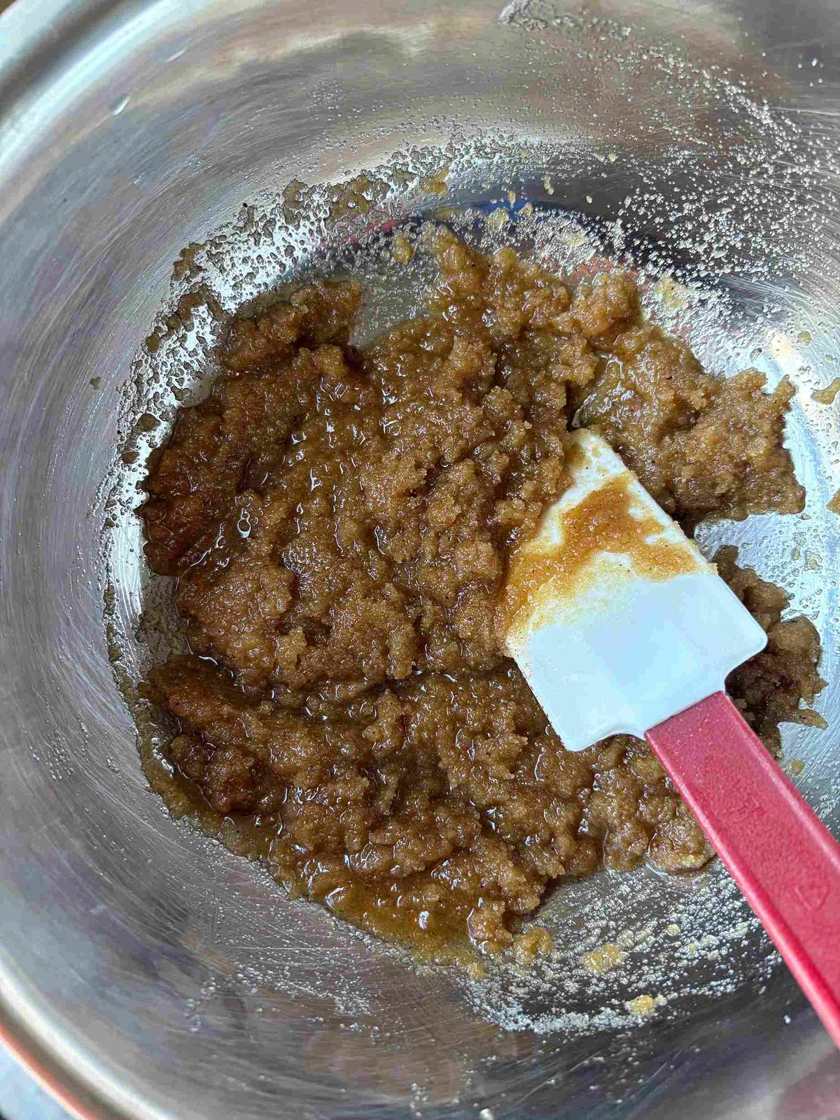 Mixing sugar into brown butter with spatula.