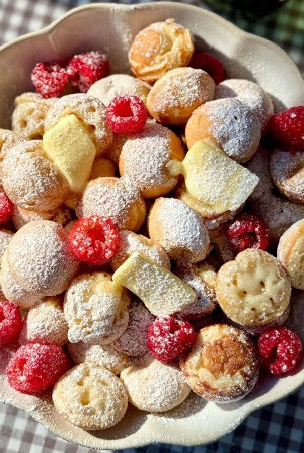 poffertjes in bowl with butter and raspberries.