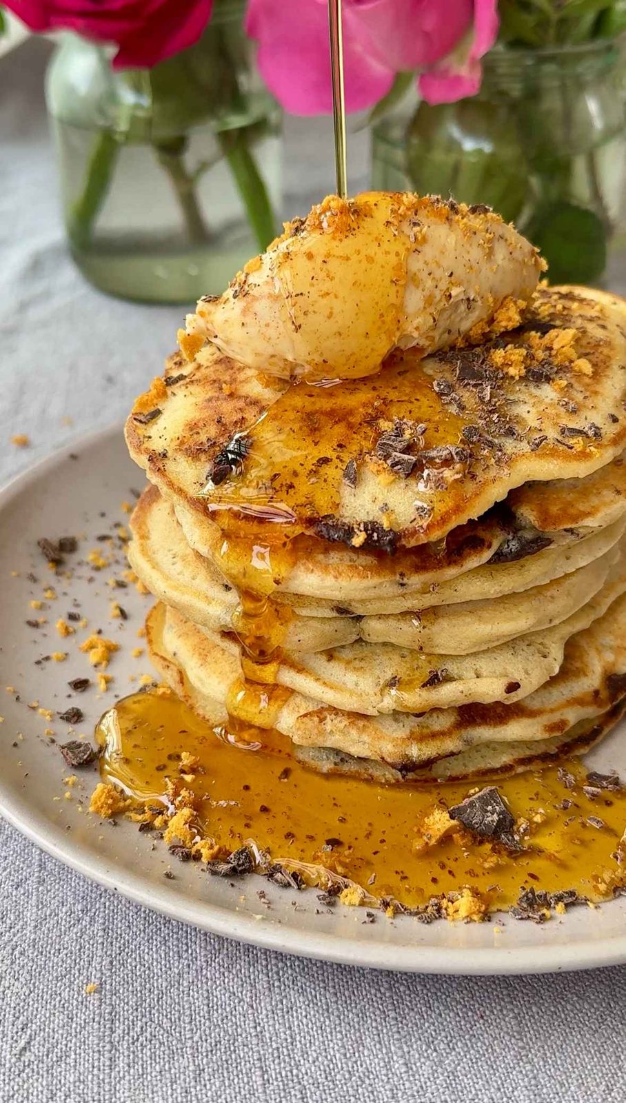 a stack of chocolate chip pancakes with syrup.