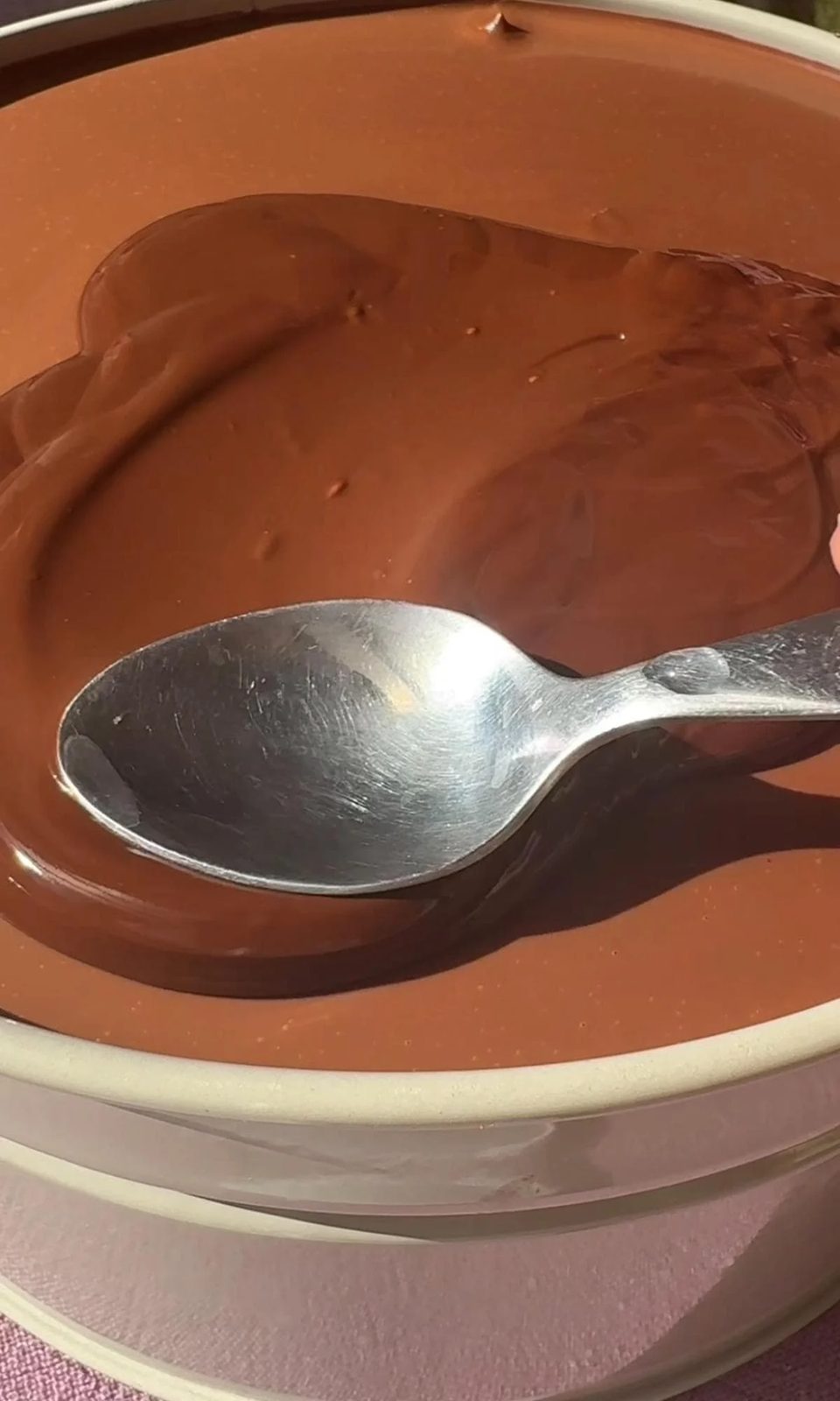 Spreading crackly chocolate to the top of chocolate cake.