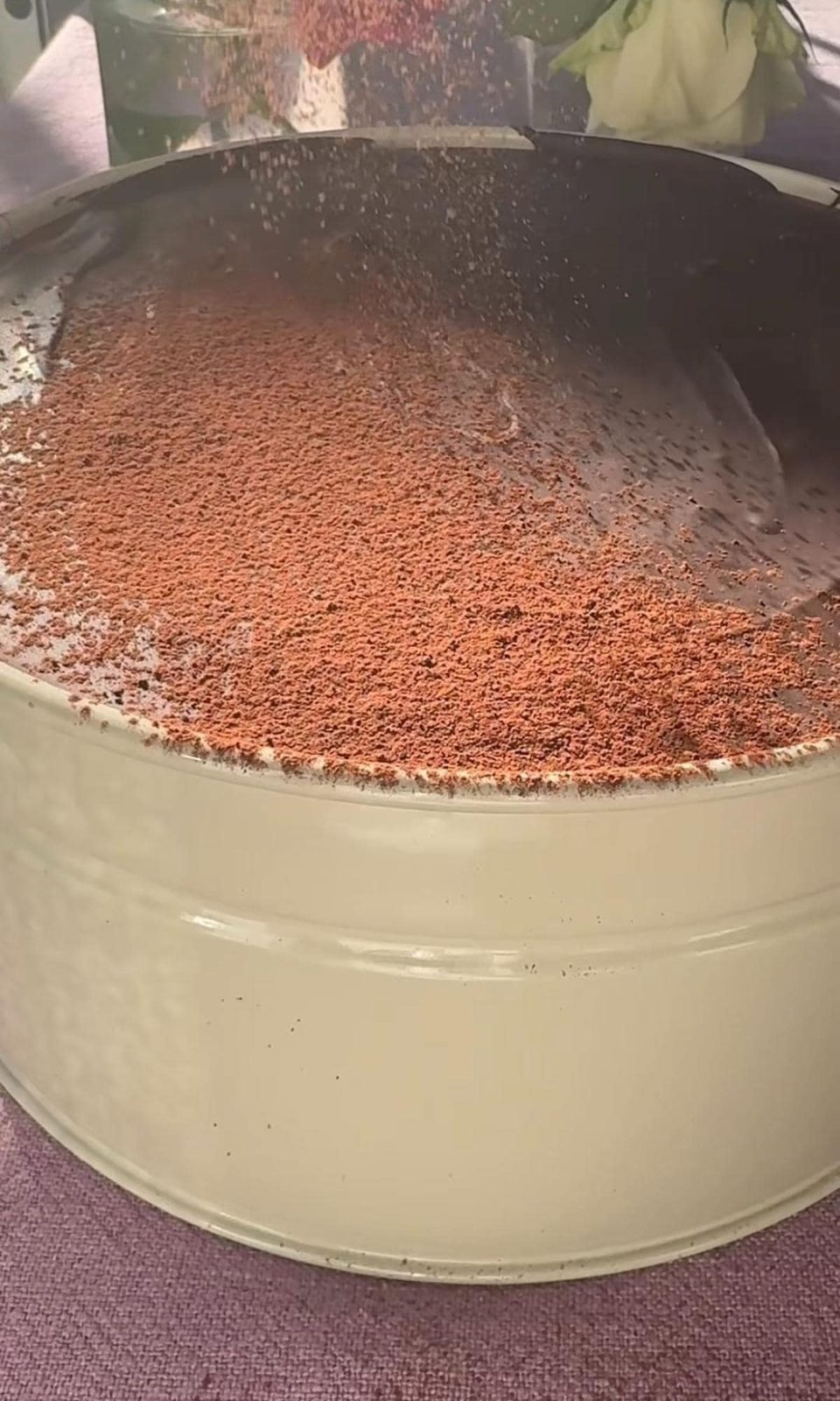 Dusting chocolate cake with cocoa powder.