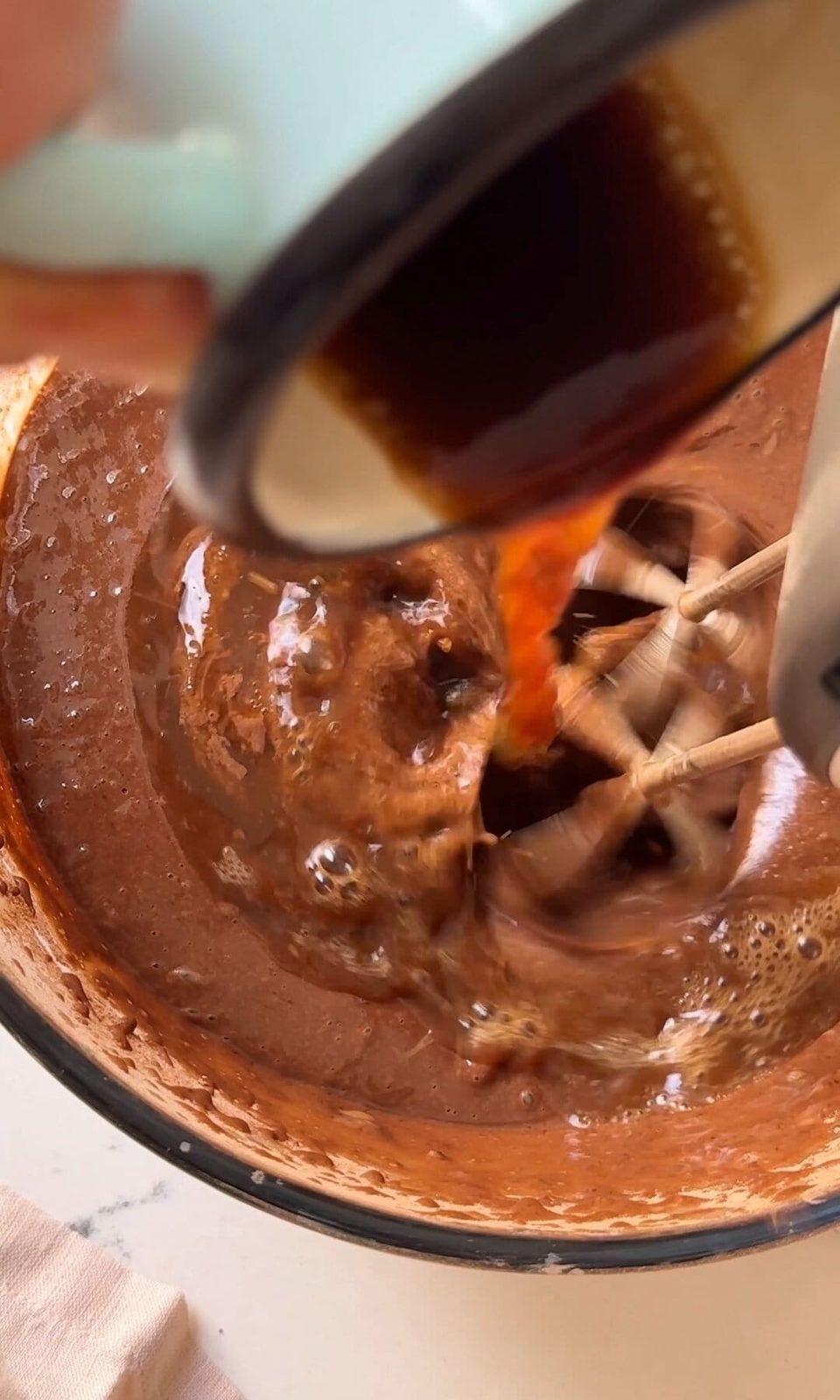 pouring hot coffee into chocolate fudge cake batter.