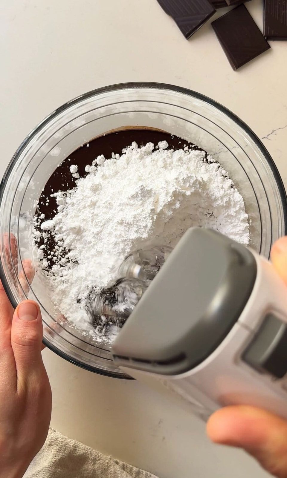 whipping icing sugar into chocolate icing.