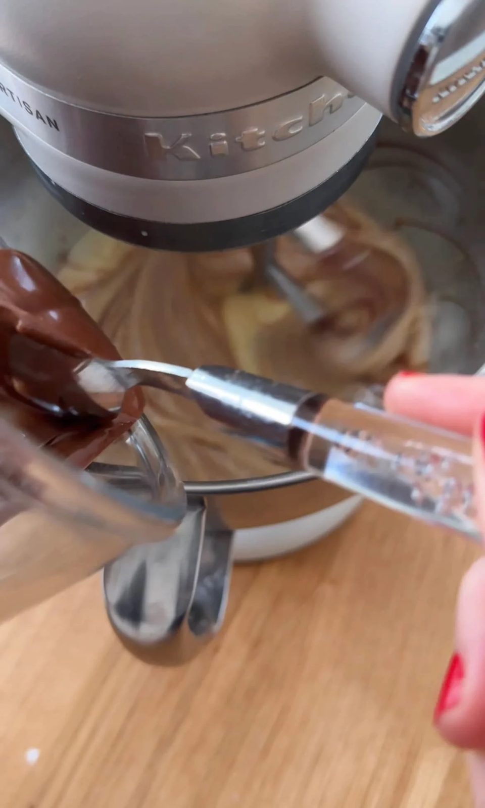 adding melted chocolate to the cake batter.