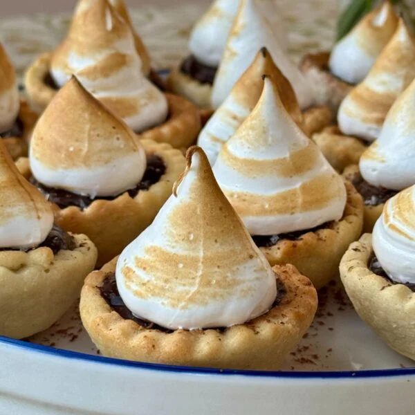chocolate tarts with meringue topping on a plate.
