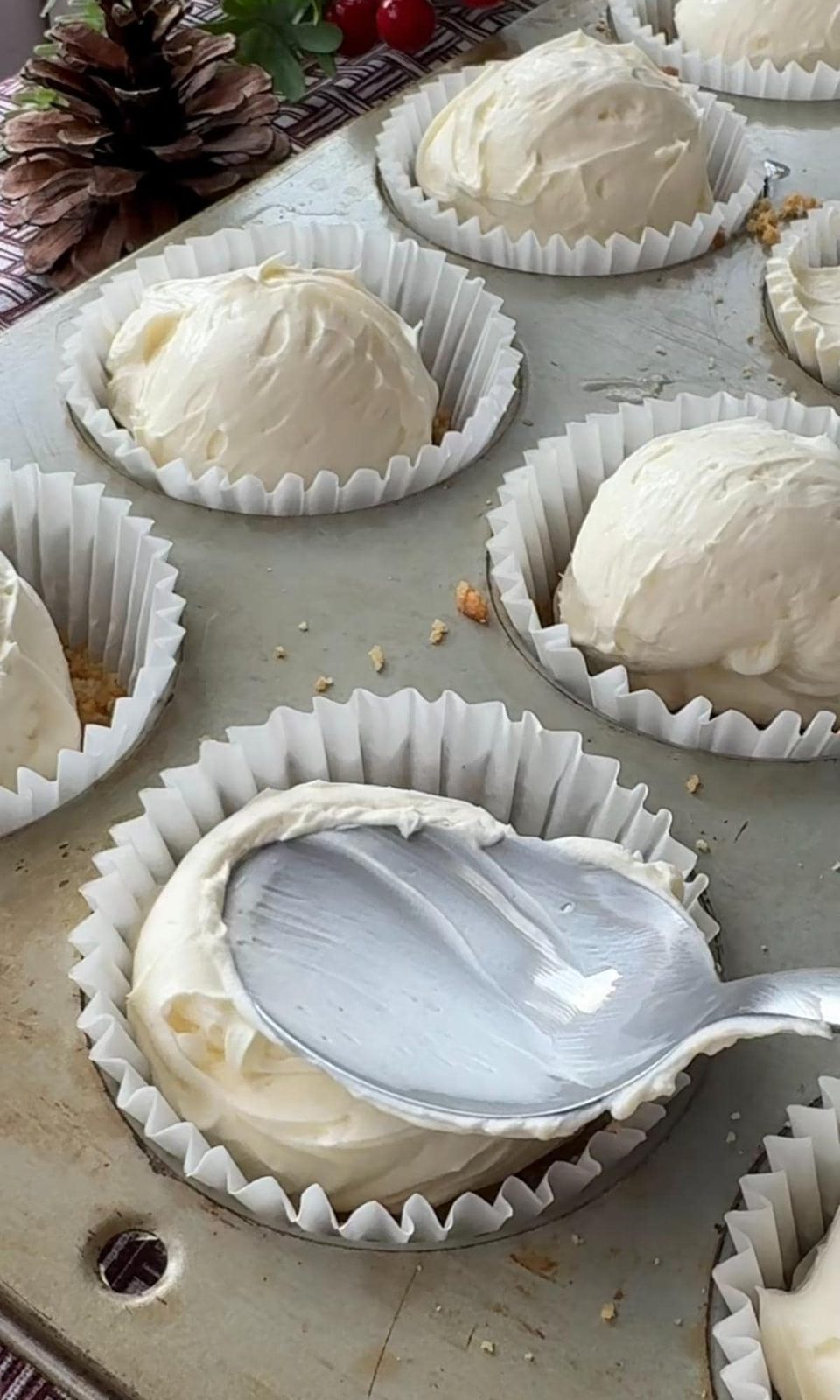 Smoothing cheesecake into cases.