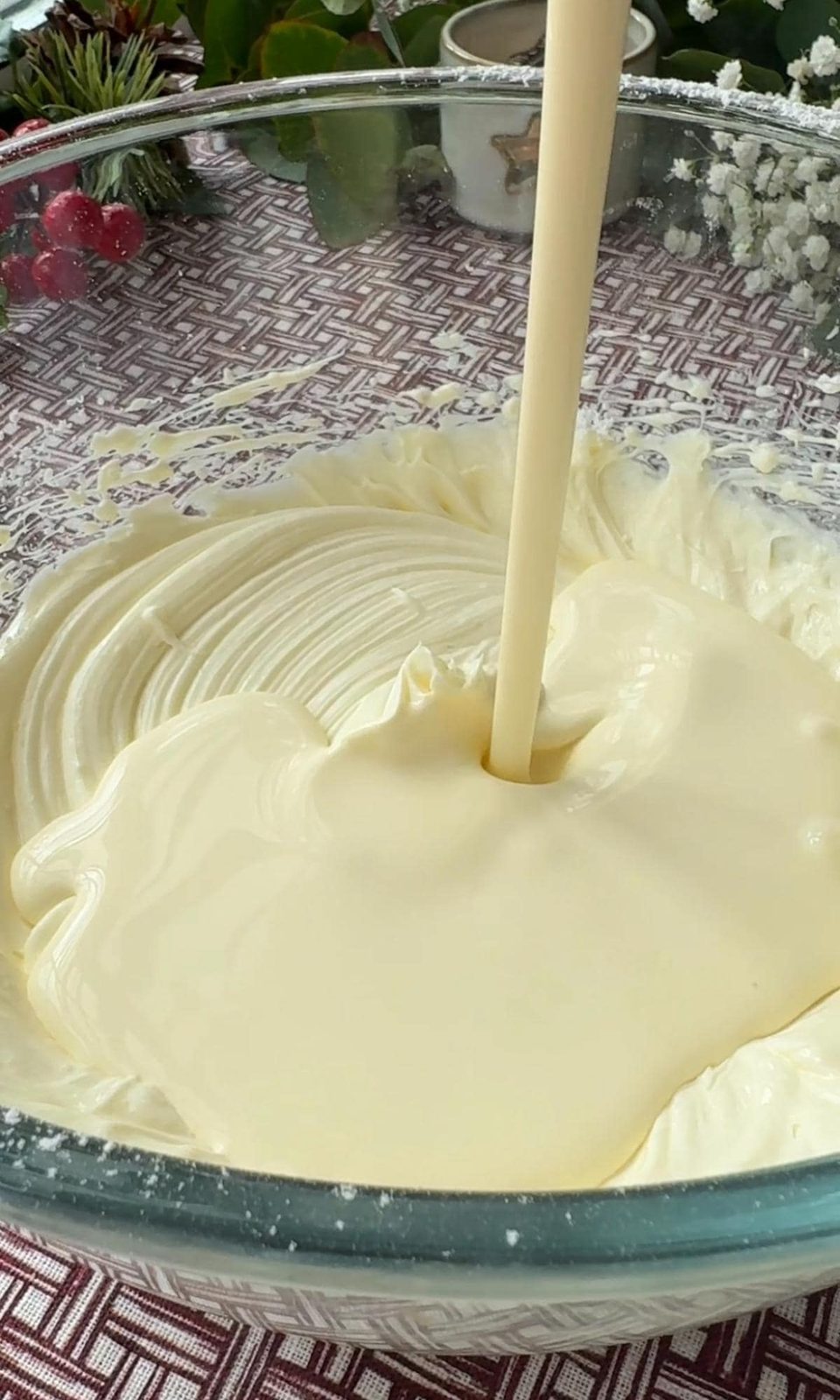 Adding double cream to cheesecake mix.