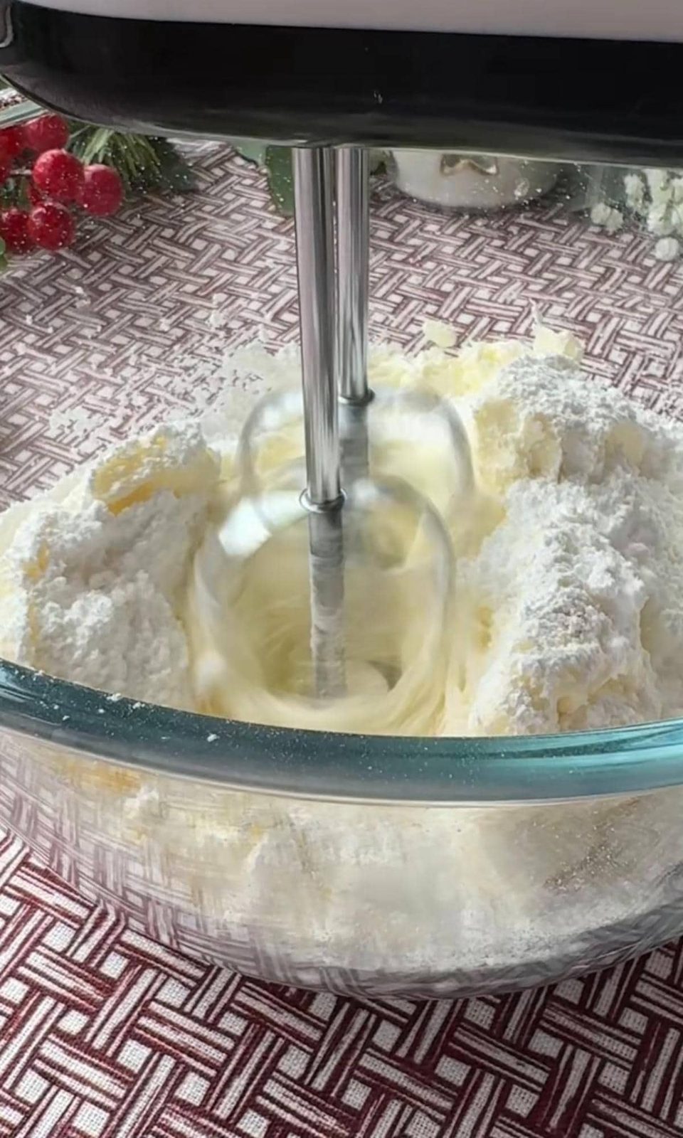 Mixing cream cheese and sugar with hand mixer.