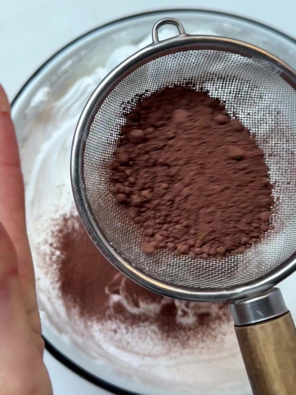 Adding cocoa powder to whipped egg whites.
