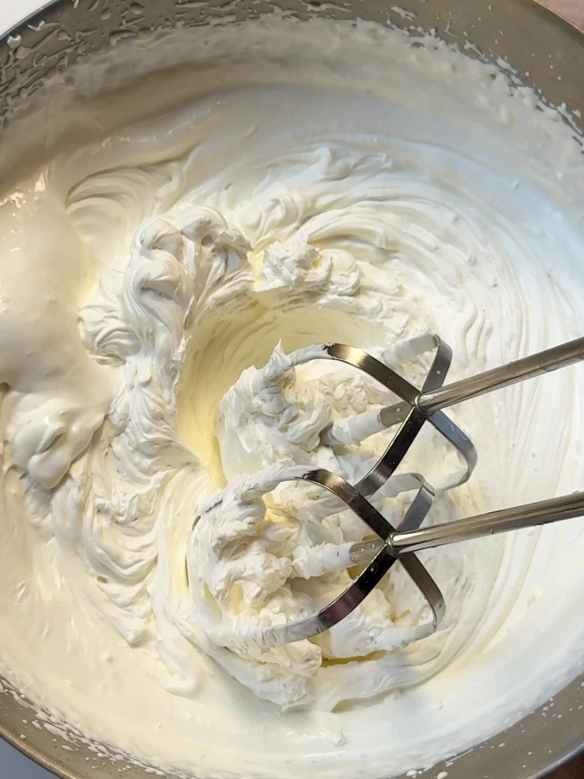 Whipping cream in a mixing bowl.