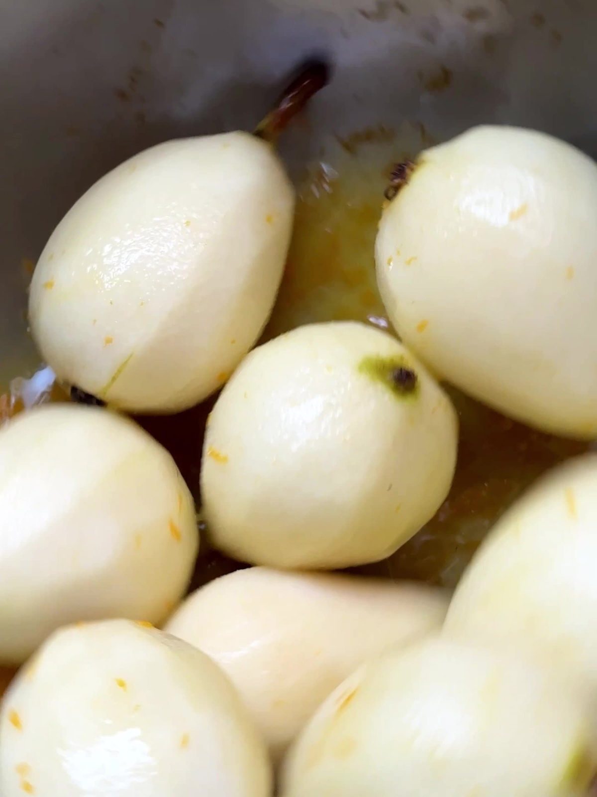 Peeled pears in orange juice.