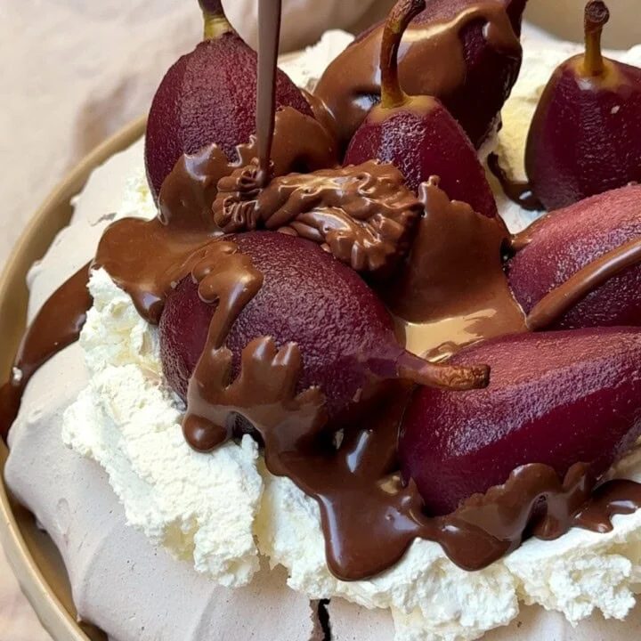 Drizzling chocolate sauce over poached pear Pavlova.