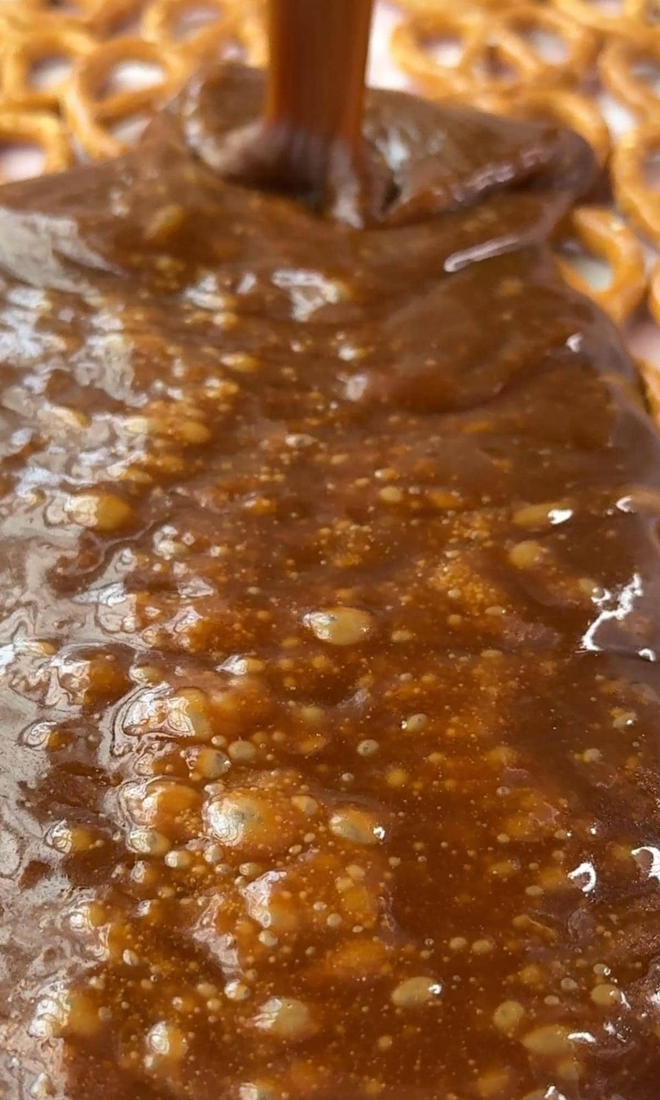 Pouring toffee over pretzels.