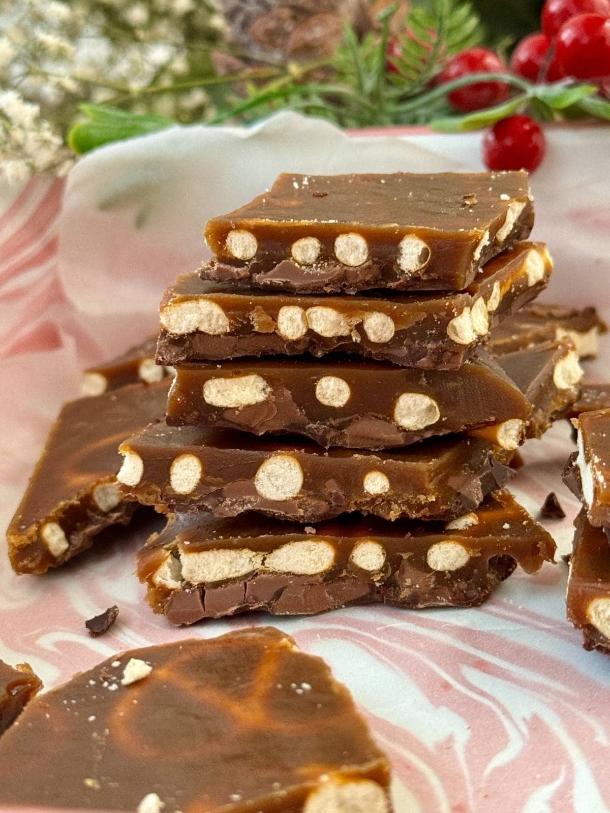 Christmas pretzel crack stacked on a tray.