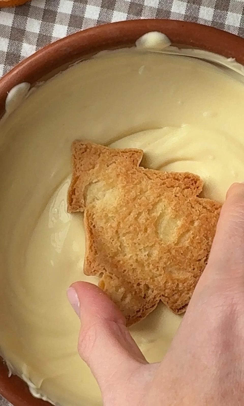 dipping christmas tree cookies into white chocolate.