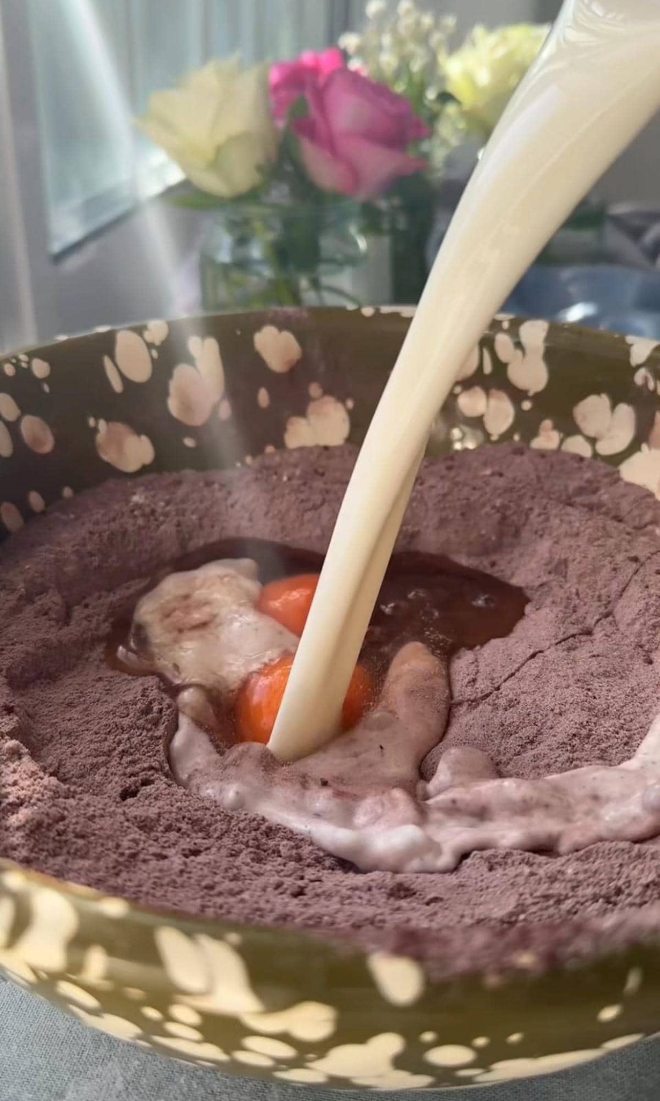 adding eggs and milk to the chocolate cake batter.
