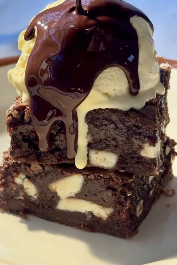 chocolate and white chocolate brownies stacked with ice cream on top.