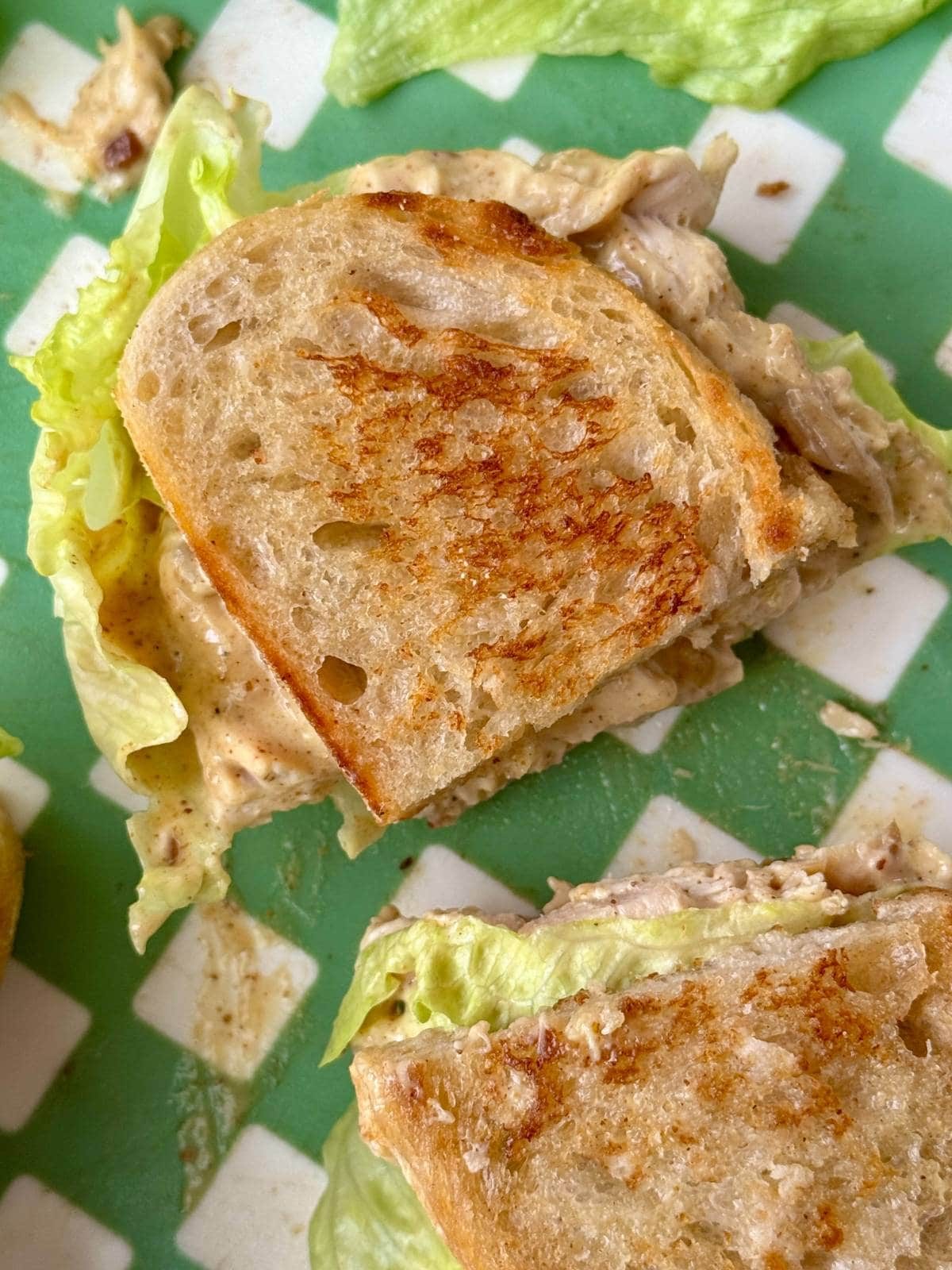 chicken coronation sandwich in half with lettuce.