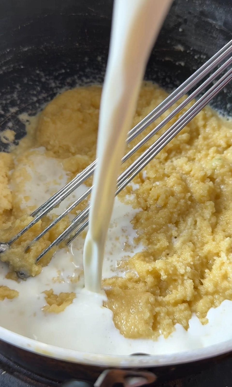 Adding milk to a roux.
