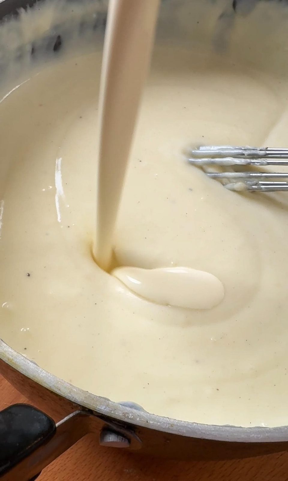 Adding cream to cheese sauce.