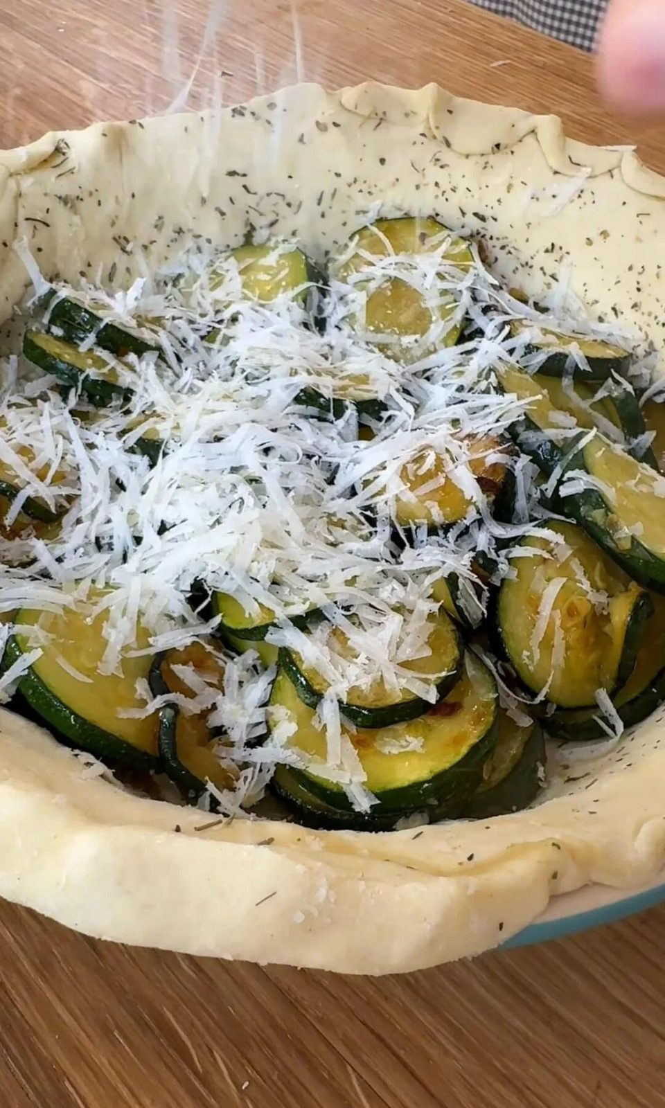 adding parmesan to the quiche.