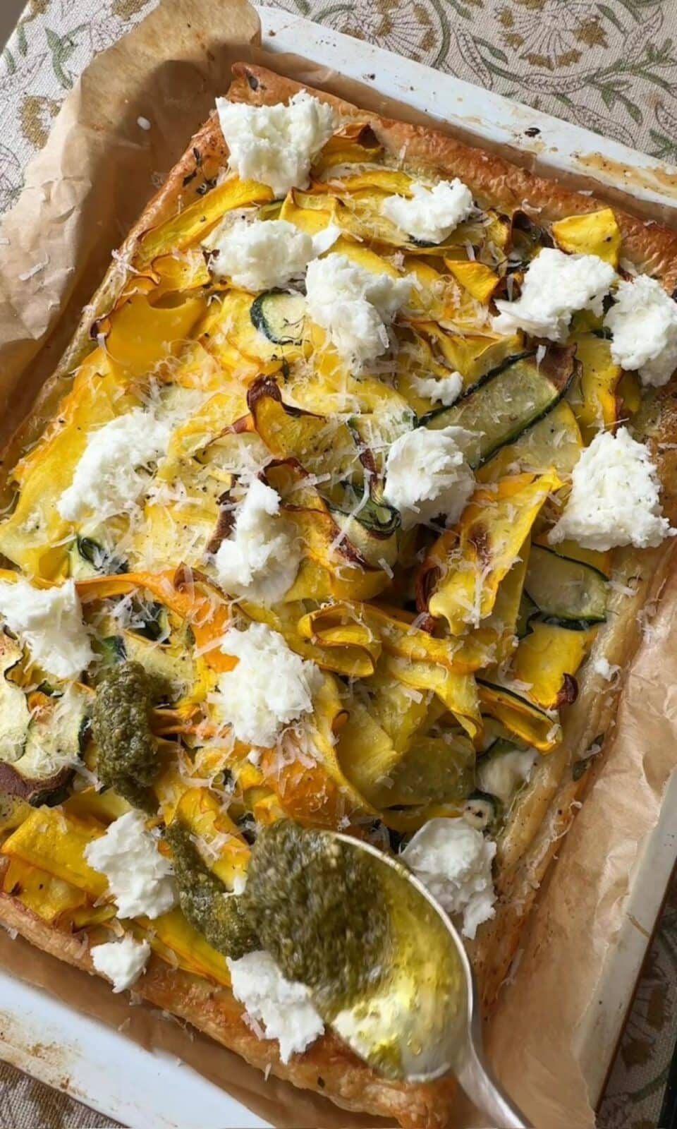 drizzling pesto on courgette tart.