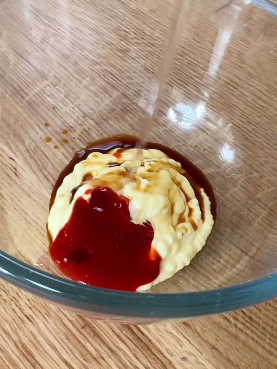 Making sriracha mayo sauce in bowl.