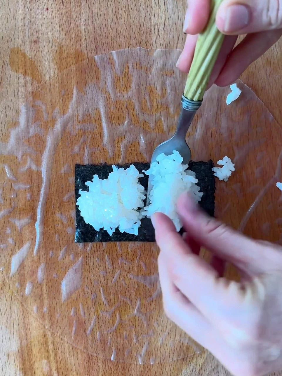 Filling rice paper with rice and nori.
