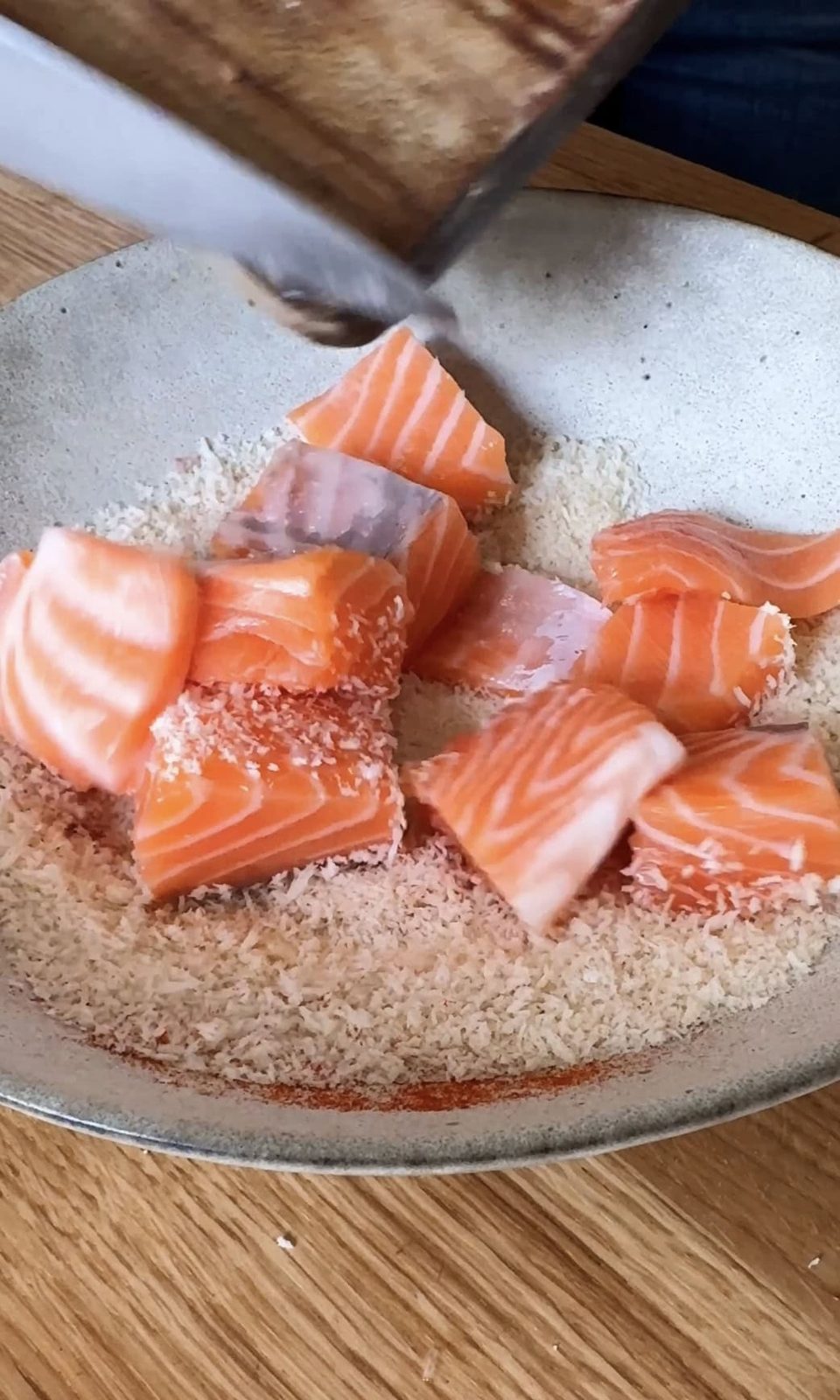 tossing salmon in panko.