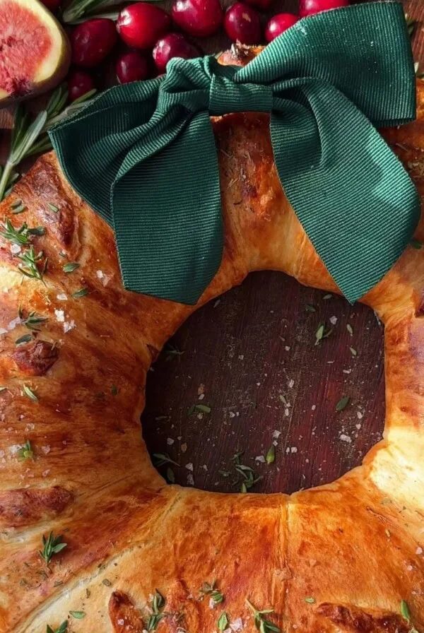 Bacon Brie Crescent Wreath with ribbon on table.