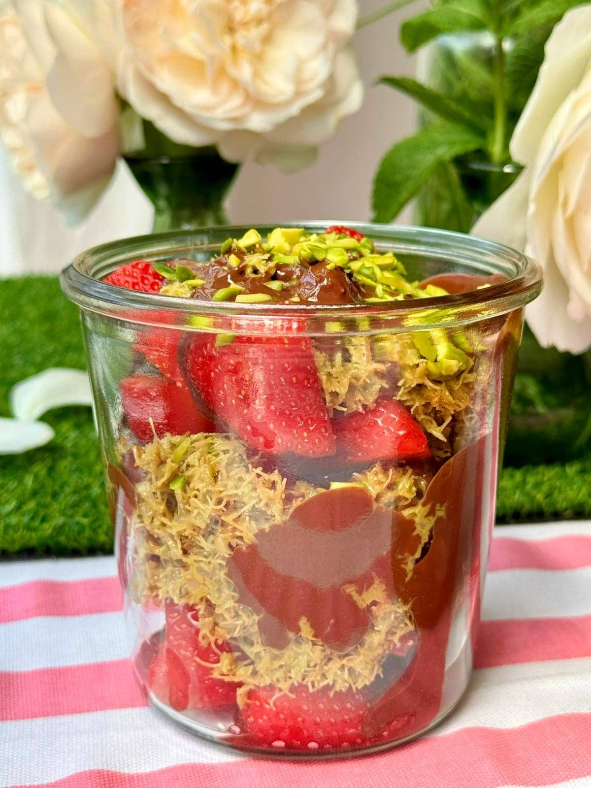 a glass filled with dubai chocolate strawberry.