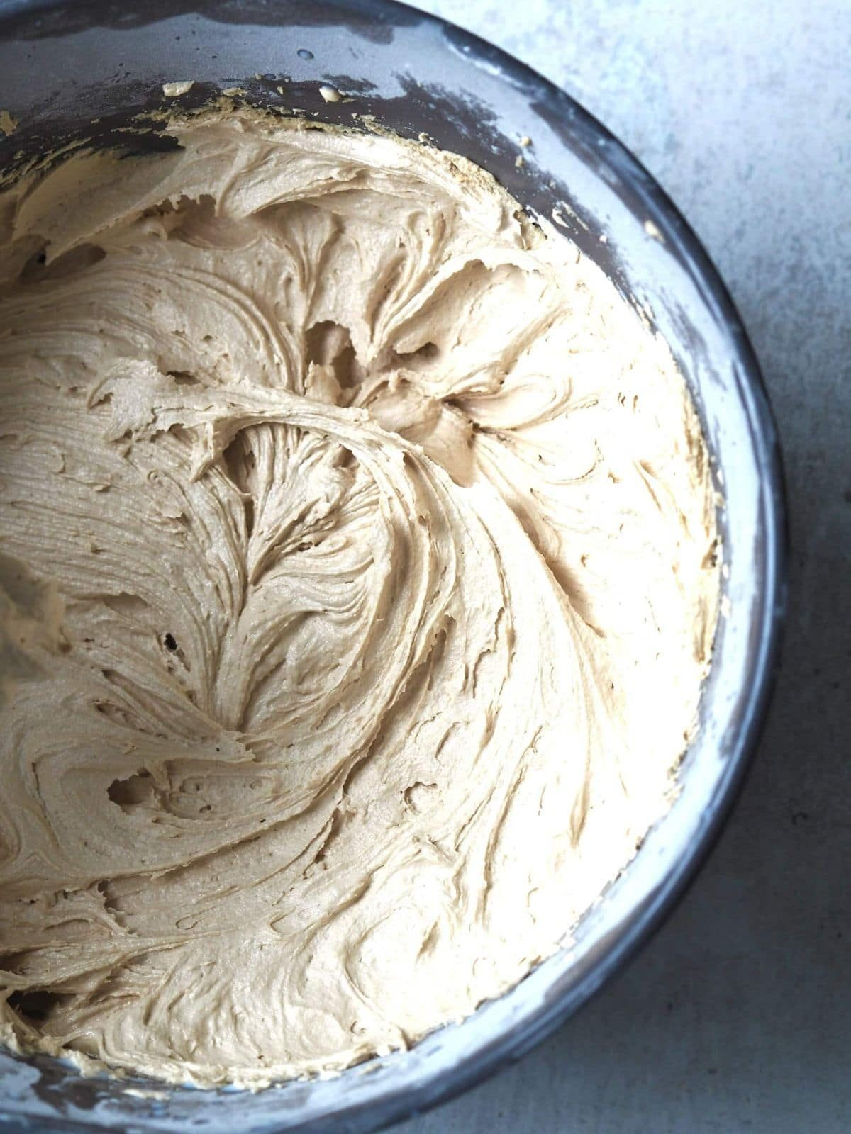 Ahipping biscoff buttercream frosting in bowl.