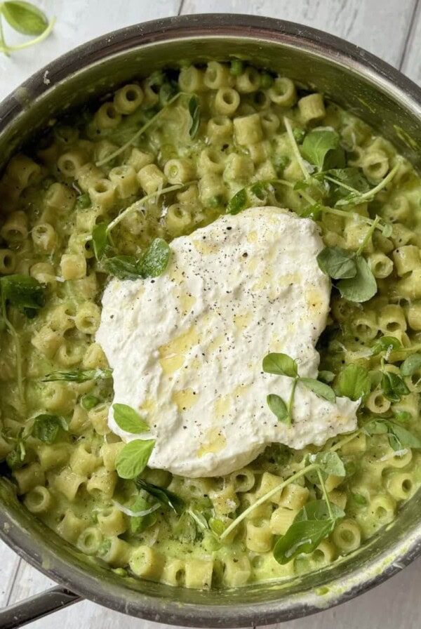 pasta and peas in a pan with burrata.
