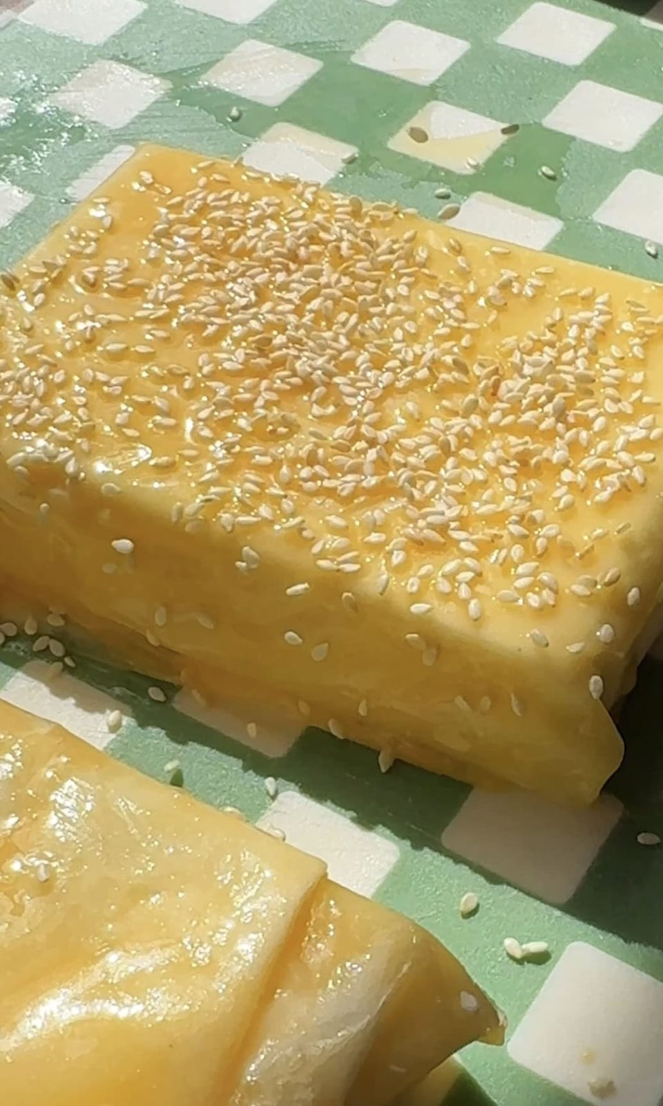 sprinkling feta saganaki with sesame seeds.