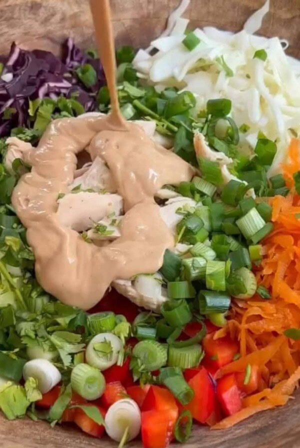 thai peanut salad pouring dressing on.