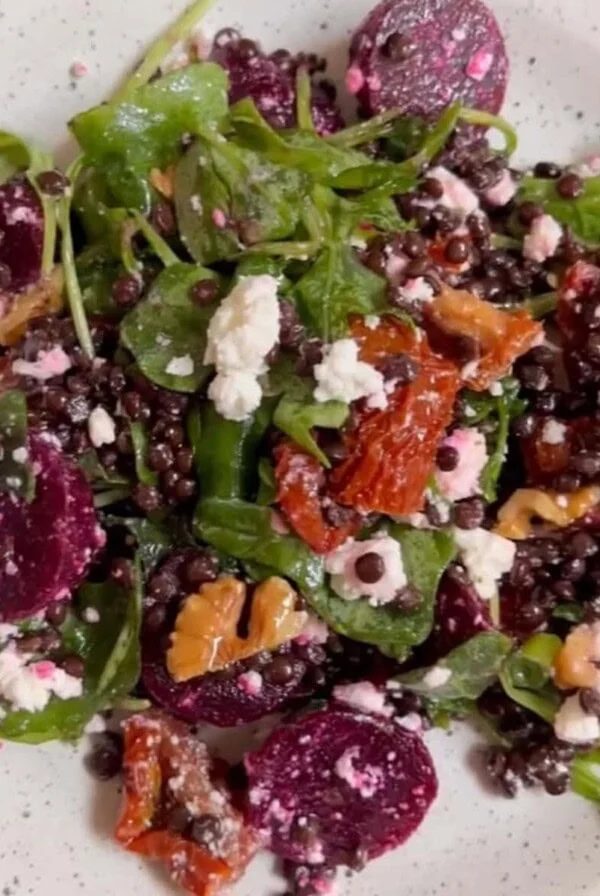 Beetroot and feta salad with arugula on white plate..
